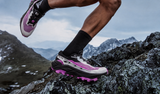 Trail running shoes on snowy mountain terrain